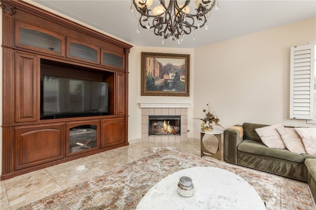 living room with a tile fireplace and a notable chandelier