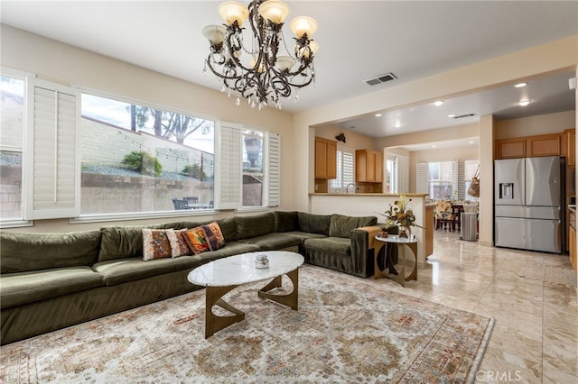 living room featuring a healthy amount of sunlight and an inviting chandelier