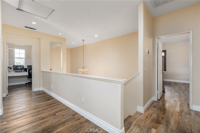 corridor featuring dark hardwood / wood-style flooring and a chandelier