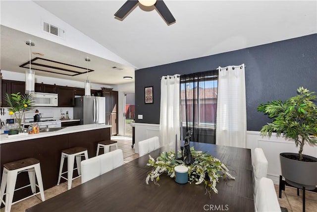 dining area with vaulted ceiling, ceiling fan, and light tile patterned flooring