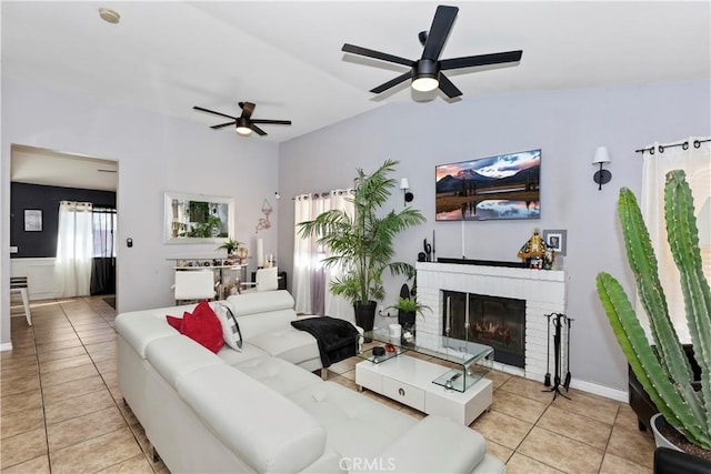 tiled living room featuring a fireplace and ceiling fan