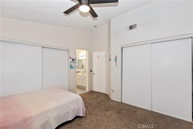 carpeted bedroom featuring sink, ensuite bath, and ceiling fan