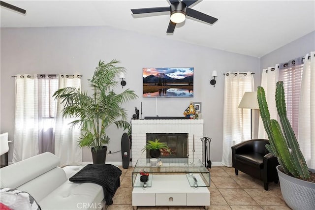 tiled living room featuring lofted ceiling, a brick fireplace, and a wealth of natural light