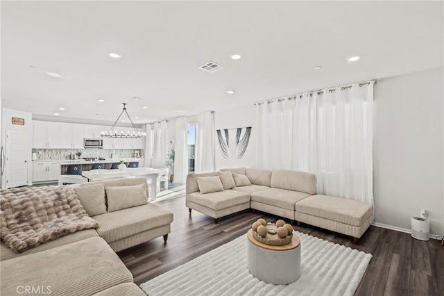 living room with dark hardwood / wood-style floors and a chandelier