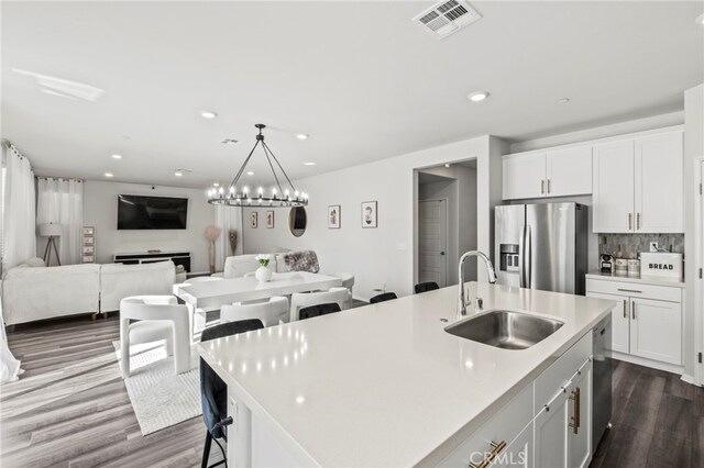 kitchen featuring white cabinetry, appliances with stainless steel finishes, an island with sink, and sink