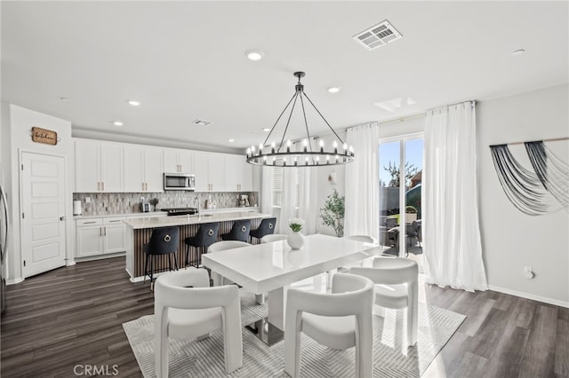 dining room featuring dark hardwood / wood-style flooring and a notable chandelier