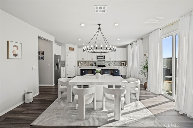 dining room with hardwood / wood-style flooring and a chandelier