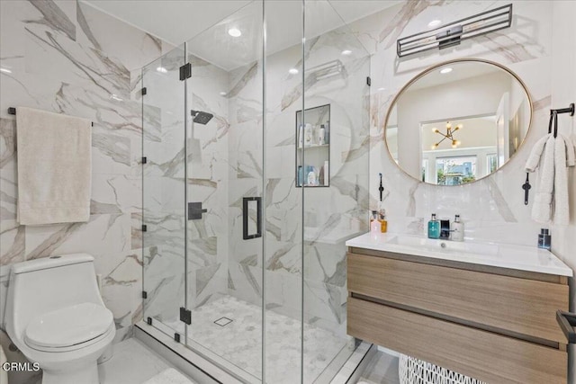 bathroom with tile walls, vanity, walk in shower, toilet, and an inviting chandelier