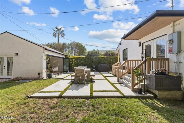 view of yard featuring a patio and french doors