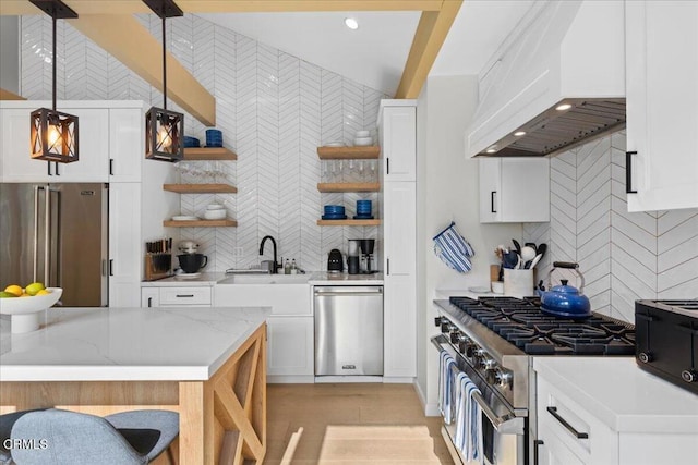 kitchen with pendant lighting, premium range hood, high end appliances, light stone counters, and white cabinets