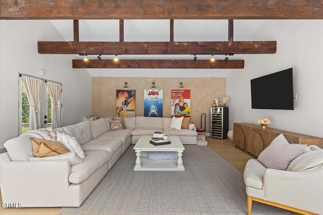 living room featuring beamed ceiling, hardwood / wood-style flooring, track lighting, and high vaulted ceiling