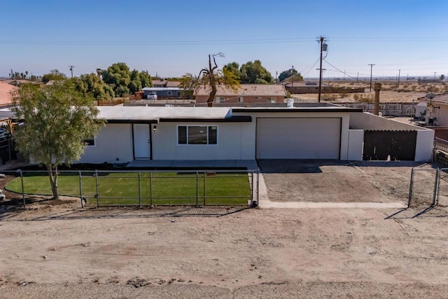 ranch-style home featuring a garage and a front lawn