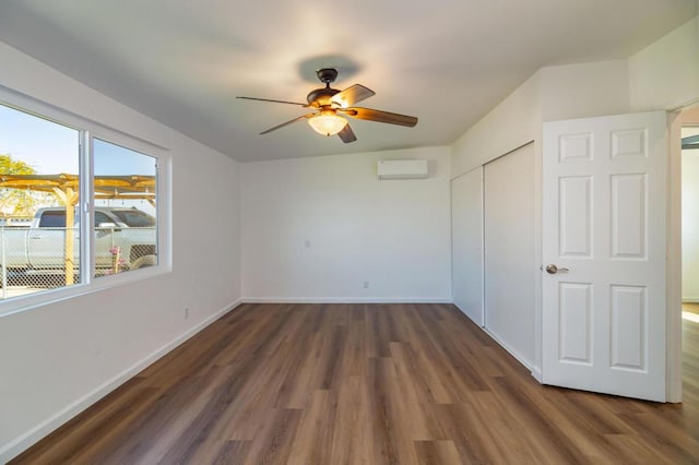 unfurnished bedroom featuring dark wood-type flooring, ceiling fan, a closet, and an AC wall unit