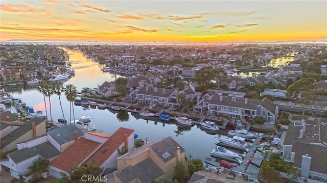 aerial view at dusk featuring a water view