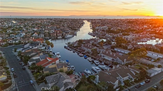 aerial view at dusk featuring a water view