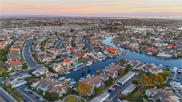 aerial view at dusk featuring a water view