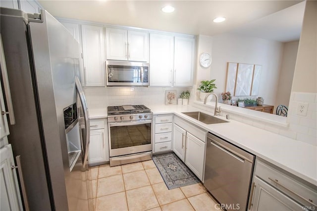 kitchen featuring sink, white cabinets, backsplash, kitchen peninsula, and stainless steel appliances