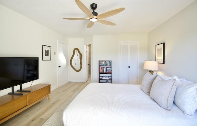 bedroom with ceiling fan, light hardwood / wood-style floors, and a closet