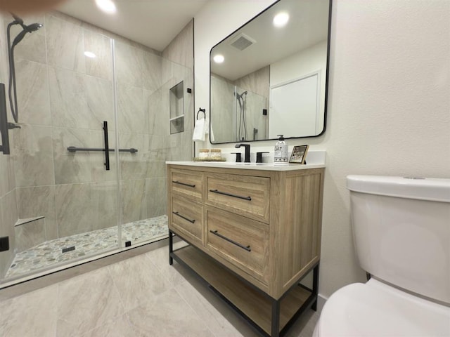 bathroom featuring vanity, toilet, and tiled shower