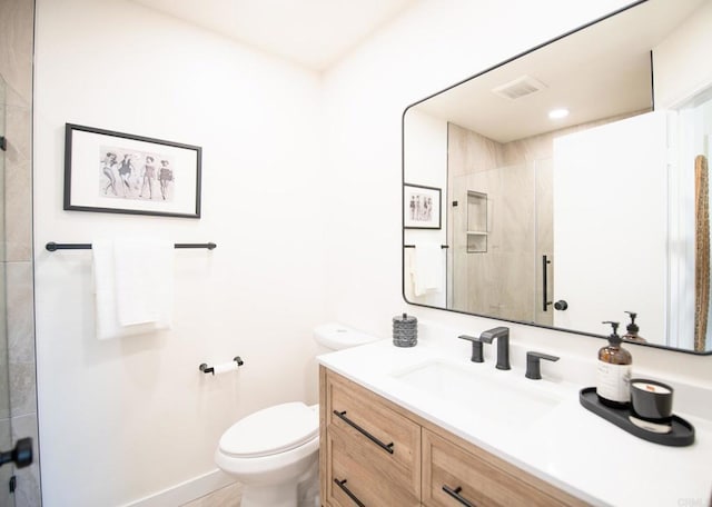 bathroom featuring vanity, toilet, and a shower with door