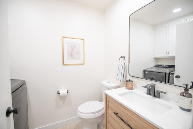 bathroom with vanity, independent washer and dryer, and toilet