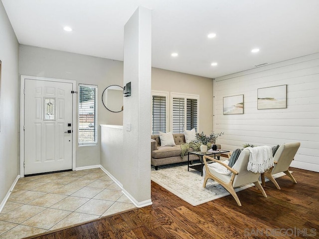 foyer featuring wooden walls and light hardwood / wood-style floors