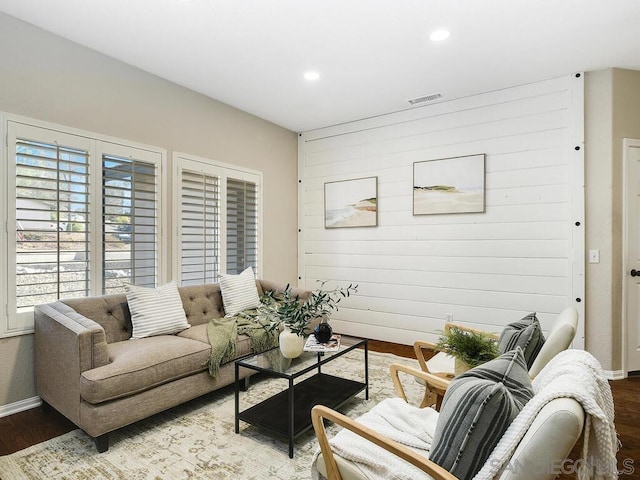 living room with wood-type flooring and wooden walls