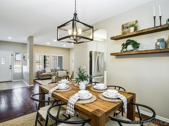 dining room with a notable chandelier and dark hardwood / wood-style flooring