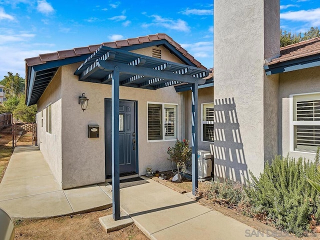 doorway to property featuring a pergola