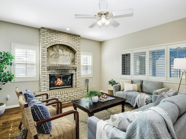 living room with hardwood / wood-style floors, ceiling fan, a healthy amount of sunlight, and a brick fireplace