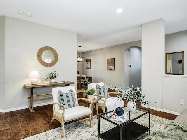 living room featuring wood-type flooring and a notable chandelier