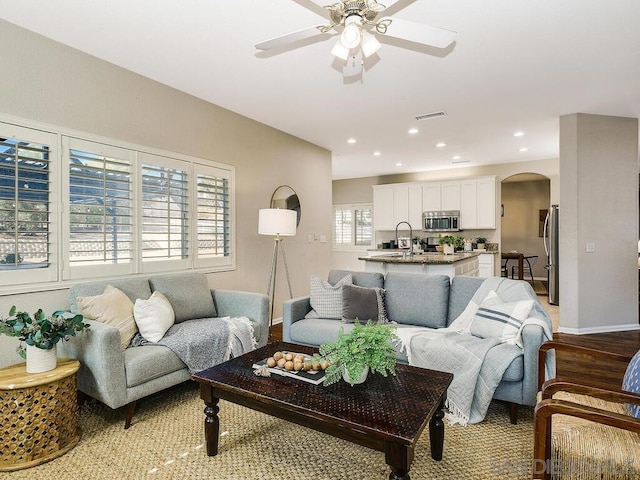 living room featuring ceiling fan and light hardwood / wood-style flooring