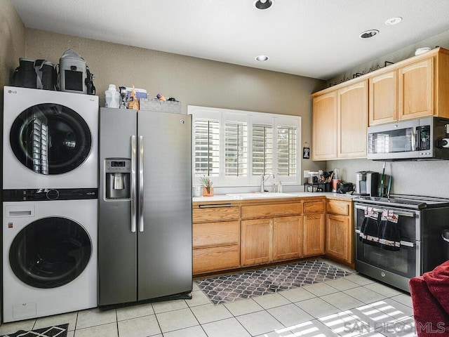 kitchen featuring stainless steel appliances, stacked washer and dryer, sink, and light tile patterned floors