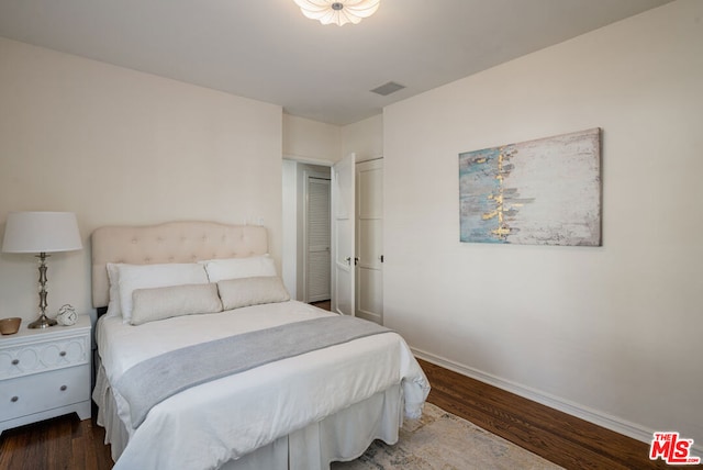 bedroom with dark hardwood / wood-style floors