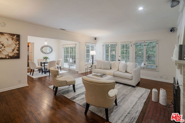 living room with dark wood-type flooring and ornamental molding