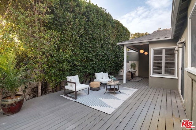 deck featuring an outdoor living space with a fire pit