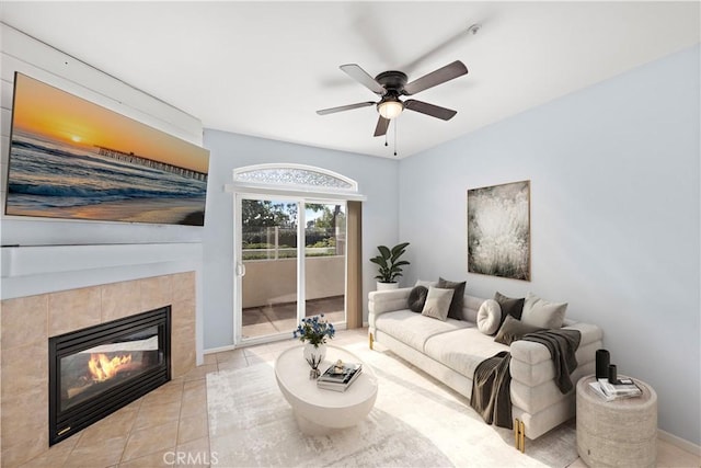 tiled living room with ceiling fan and a fireplace