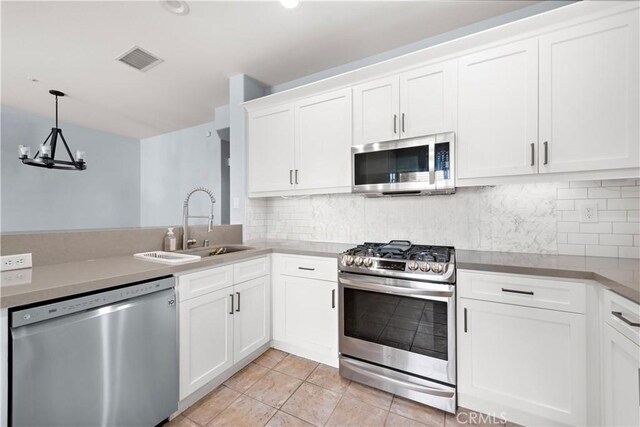 kitchen featuring tasteful backsplash, appliances with stainless steel finishes, sink, and white cabinets