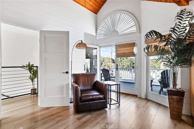 living area featuring high vaulted ceiling and light hardwood / wood-style flooring