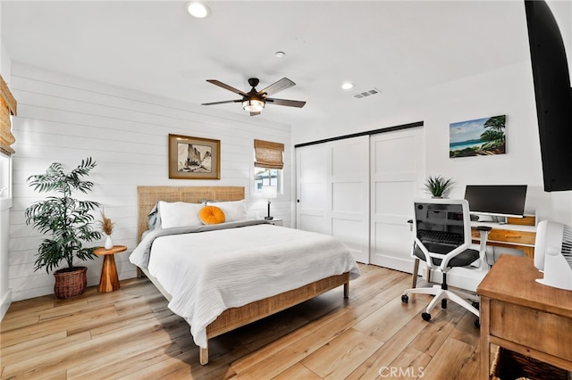 bedroom with a closet, ceiling fan, and light wood-type flooring