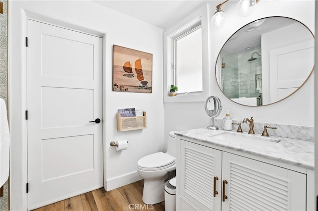 bathroom with hardwood / wood-style flooring, vanity, a shower with door, and toilet