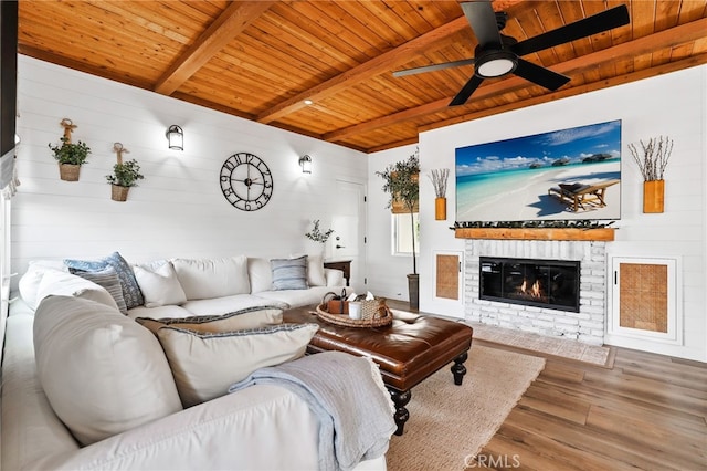 living room with ceiling fan, wood ceiling, wood-type flooring, and beamed ceiling