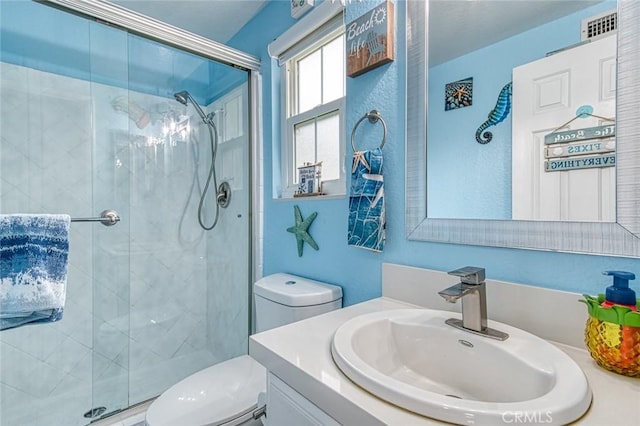 bathroom featuring walk in shower, vanity, and toilet