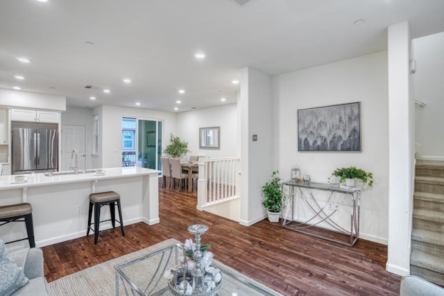 living room with dark hardwood / wood-style flooring and sink