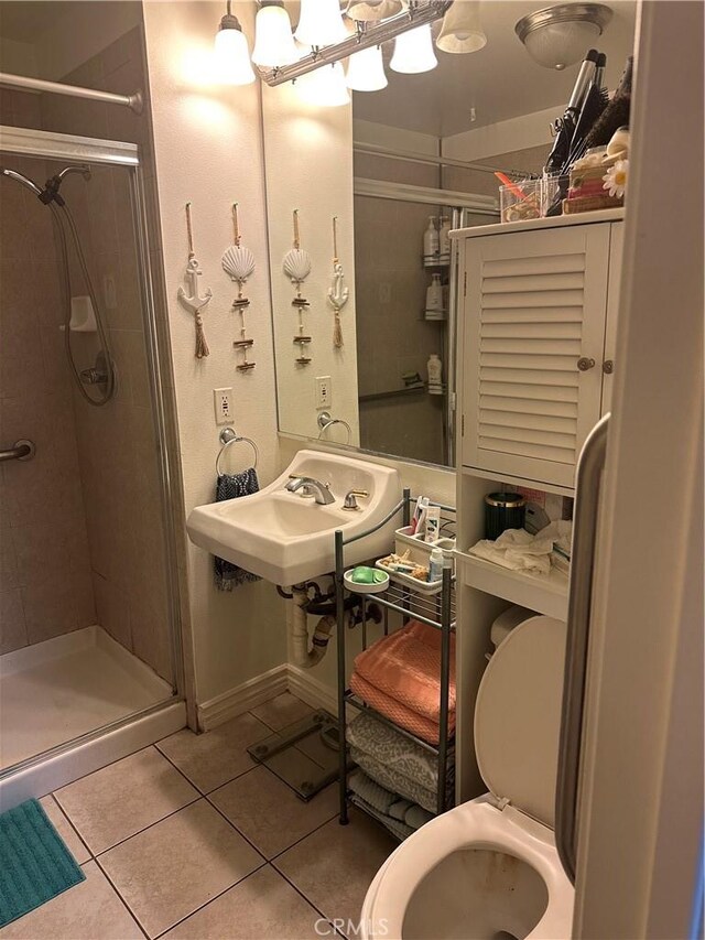 bathroom with tile patterned floors, sink, and a shower with door