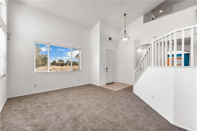 entrance foyer featuring light colored carpet and high vaulted ceiling