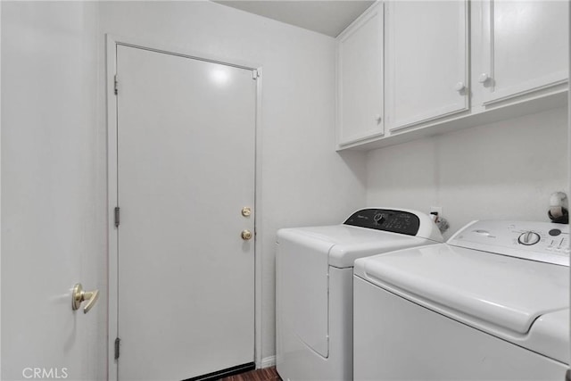 clothes washing area featuring cabinets, dark hardwood / wood-style floors, and washing machine and dryer