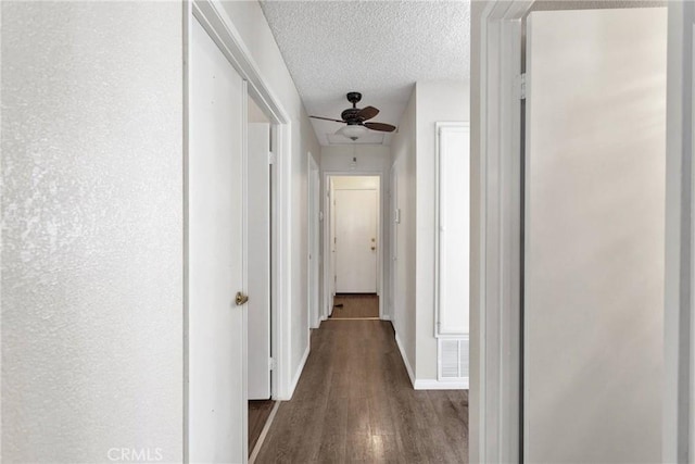 hall featuring dark hardwood / wood-style flooring and a textured ceiling