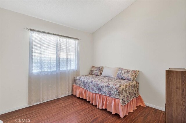 bedroom with hardwood / wood-style floors and vaulted ceiling