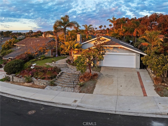 view of property hidden behind natural elements featuring a garage